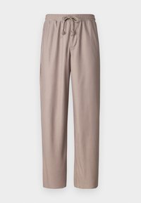 Pantalons en drawstring marron clair avec une texture côtelée, une taille élastique et des poches latérales. Coupe ample avec des jambes droites.