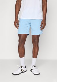 Pantalones cortos deportivos de color azul claro, hechos de un tejido ligero, con cintura elástica, bolsillos laterales y un detalle de logo en la pierna.