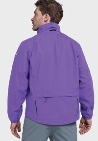 Lila wasserdichte Jacke mit hohem Kragen, schwarzen Reißverschlüssen, elastischen Bündchen und verstellbarem Saum. Rückentaschen-Detail sichtbar. Leichtes Design.