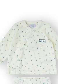 Conjunto de bebé color crema que incluye una camiseta cruzada de manga larga con estampados azules de dientes de león y botones a presión, combinada con pantalones a juego con cintura elástica.