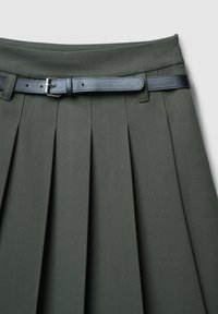 Gonna verde plissettata con una texture liscia, caratterizzata da una cintura in pelle nera con fibbia argento. Il design comprende molteplici pieghe verticali.