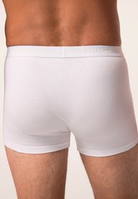 Boxers ajustados de algodón blanco con una cinturilla suave, con marca en relieve, diseño ajustado y textura suave.