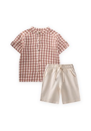 Ružová a biela károvaná košeľa s krátkym rukávom na gombíky v kombinácii s béžovými šortkami s elastickým pásom a šnúrkou.