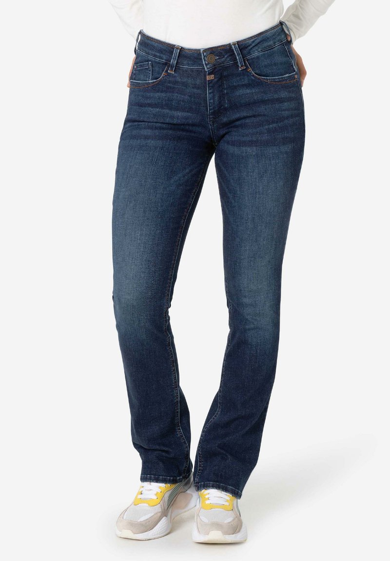 Donkerblauwe denim jeans met een slanke pasvorm, klassieke vijf-pocketstijl, en contrasterende oranje stiksels langs de naden.