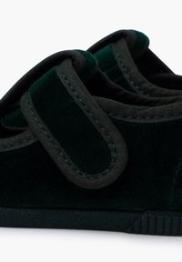 Scarpe verdi in velluto con accenti in tessuto nero, dotate di una fascetta in velcro e una suola in gomma testurizzata per una maggiore aderenza. Punta arrotondata e design casual.