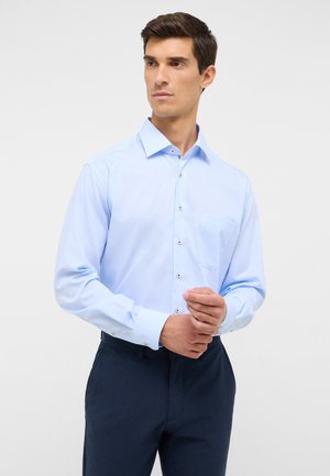 Lichtblauwe blouse met lange mouwen, een puntige kraag, een enkel borstzakje en metallic knopen. Glad stof met een lichte glans.