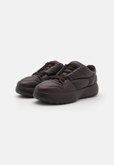 Brown leather sneakers with a chunky design, textured upper, padded tongue, and rubber sole featuring a tread pattern.