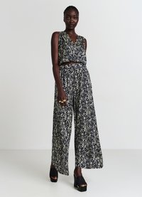 Salopette floreale blu navy, senza maniche con scollatura a V, presenta un top corto e pantaloni larghi, realizzata in tessuto leggero con un motivo strutturato.