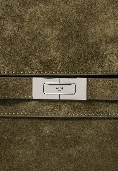 Πράσινη σουέντ τσάντα χεριού με ασημένιο μεταλλικό κλείσιμο. Λείος υφασμάτινος χαρακτήρας με λεπτομέρειες ραφής και μινιμαλιστικό σχέδιο.