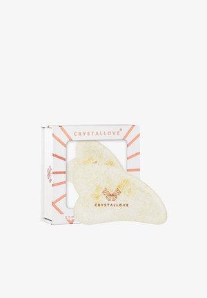 Strumento gua sha di colore bianco cremoso e biologico con venature dorate sottili, presentato in una scatola decorativa con accenti in oro rosa.