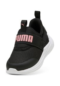Zapatilla Puma en blanco y negro con logo rosa en la correa y en el tirador trasero, parte superior de malla y suela blanca gruesa, vista frontal en ángulo.