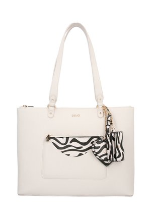 Borsa tote in ecopelle bianca con due manici, dotata di tasca frontale a righe bianche e nere e dettagli in metallo dorato.