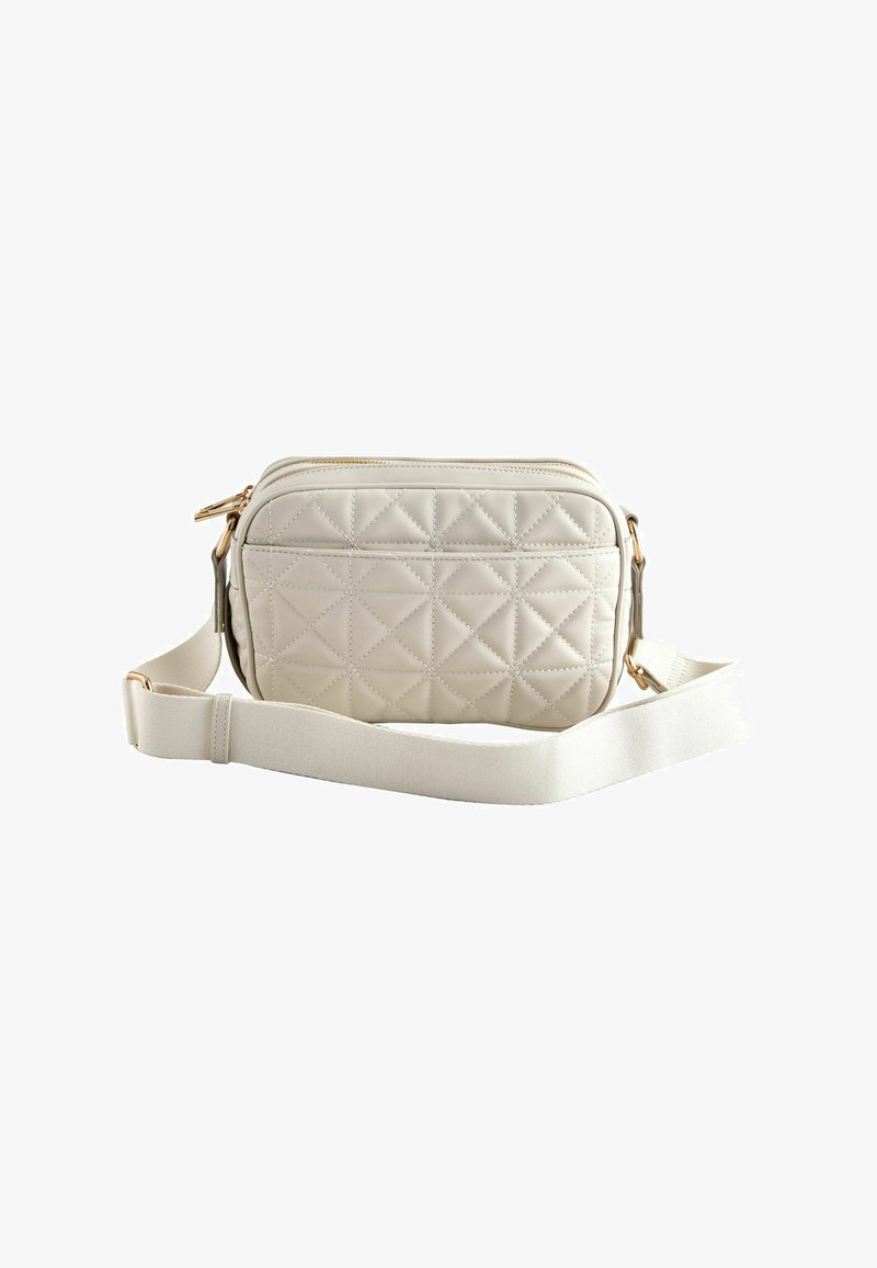 Sac bandoulière matelassé couleur crème avec bandoulière réglable et détails en métal doré, sur fond blanc.