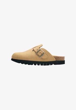 Tan suede clog with a rounded toe, adjustable buckle detail, cork midsole, and a thick black rubber sole with a wavy edge.