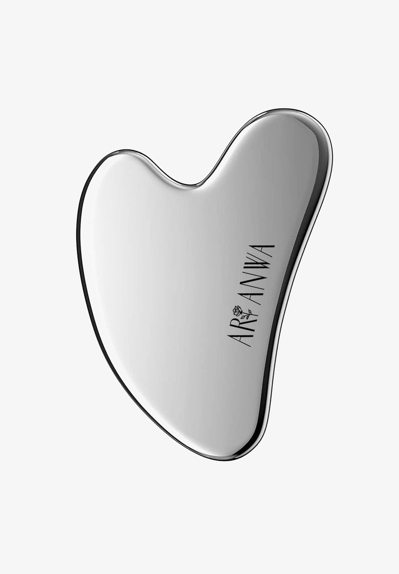 Outil de massage facial gua sha métallique lisse et poli en forme de cœur irrégulier avec le mot "AR'ANWA" imprimé dessus.