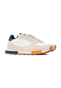 Zapatillas de serraje beige y cuero blanco con acentos en naranja y azul, que cuentan con una suela texturizada y un diseño atlético moderno.