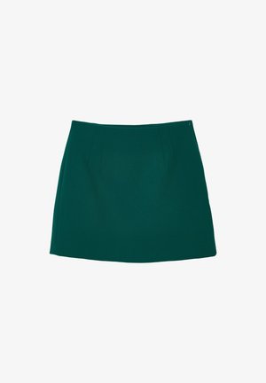 Gonna verde, lunghezza al ginocchio, realizzata in tessuto liscio con sottili pieghe sul davanti e una chiusura lampo laterale discreta. Senza motivi o accenti.