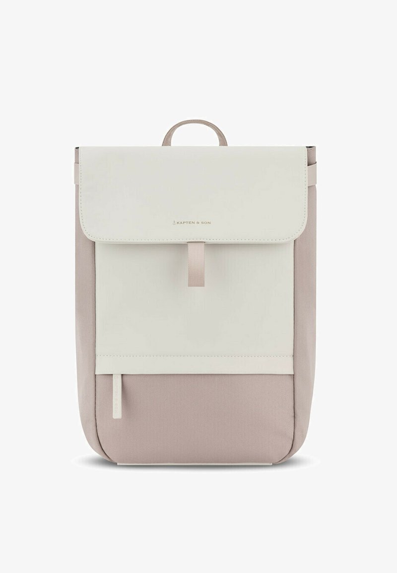 Sac à dos en tissu doux beige avec un rabat blanc. Comprend une poignée supérieure, un fermoir frontal et une poche zippée à l'avant pour un rangement supplémentaire.