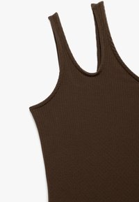 Bruine geribbelde tanktop met brede bandjes en een ronde hals. Zacht, textuur materiaal met zichtbare stikaccenten.
