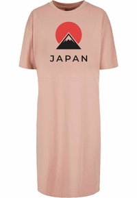 Rožinė trumpų rankovių suknelė, pagaminta iš minkštos medžiagos, su grafika, vaizduojančia Fujiman kalną, ir juodu žodžiu "JAPONIJA". Paprastas, laisvas kirpimas.