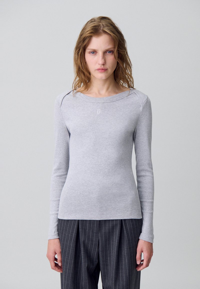Maglietta a maniche lunghe grigio chiaro realizzata in un tessuto morbido, con scollo rotondo, vestibilità slim e logo discreto sul petto.