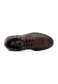 Zapato de cuero marrón con textura suave, punta redonda y detalles en hardware dorado. Incluye cordones y una cremallera lateral para un fácil acceso.