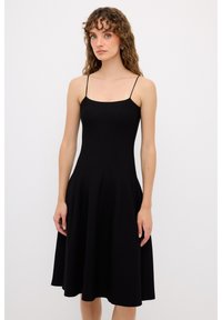 Abito nero senza maniche con corsetto aderente e gonna svasata. Realizzato in tessuto strutturato, presenta spalline sottili e scollatura quadrata.