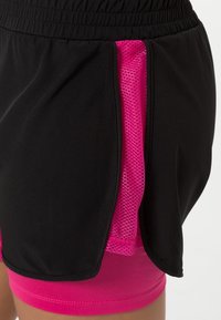 Zwarte sportshorts met een zijpaneel van mesh in felroze, voorzien van een elastische tailleband en een aansluitende binnenbroek in bijpassend roze.