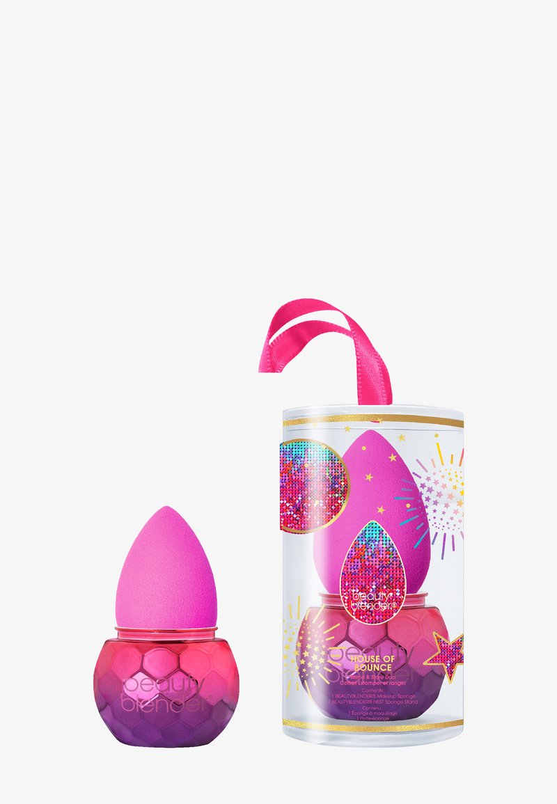 Beautyblender set met een roze spons in een hexagonale paarse en roze houder, vergezeld van een versierde cilindrische case met een lint.