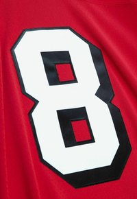 Roter Sporttrikotstoff mit großer weißer Nummer 8, die in Schwarz umrandet und auf dem Rücken gestickt ist.