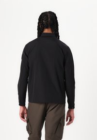 Black long-sleeve shirt with a collar, lightweight fabric, regular fit, and elastic cuffs. Seam detail at shoulders and side-slit hem.