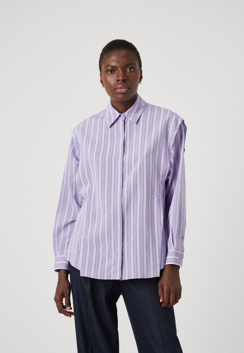 Light purple button-up shirt with vertical stripes, long sleeves, and a collar. Features a relaxed fit and cuffed sleeves.