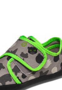 Gray fabric shoe featuring black and white animal patterns, bright green accents, elastic strap closure, and textured black sole.