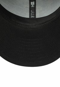 Casquette New Era noire avec une visière montrant des coutures détaillées et un doublage intérieur gris, avec une étiquette de taille et le logo New Era sur le ruban.