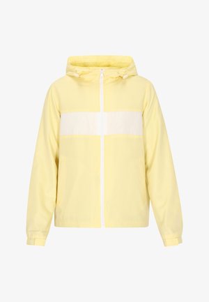 Giacca a vento gialla chiara con cappuccio, striscia orizzontale bianca, zip frontale, tasche laterali e cordini regolabili sul cappuccio.