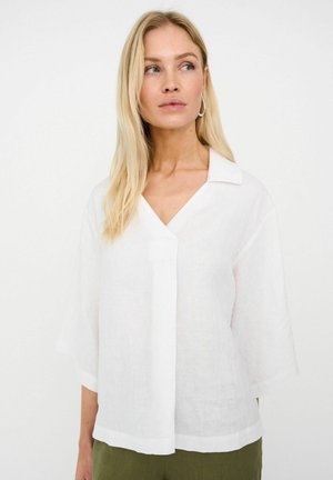 Fehér vászonblúz V-nyakkivágással és rövid, széles ujjakkal. Laza szabású, középen függőleges varrás részlettel.