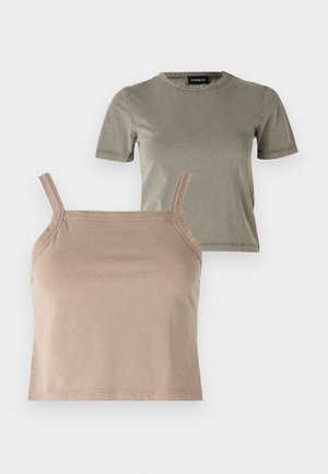 Två toppar: en kortärmad, olivgrön t-shirt och en beige, avkortad camisole med tunna axelband, båda tillverkade av mjukt bomullsblandat tyg.