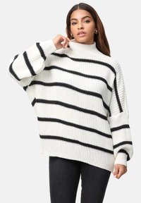 Flauschiger Strickpullover mit horizontalen schwarzen Streifen auf weißem Grund, hohem Kragen und seitlichen Schlitzen für eine lockere Passform.