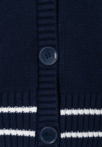 Navy blue knit fabric with ribbed texture, two dark blue buttons, and white horizontal stripes near the bottom edge.