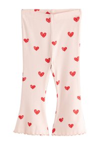 Svetloružové rebrované legíny s červenými srdiečkovými vzormi po celej ploche. Majú rozšírený lem a na spodku vlnkové okraje.