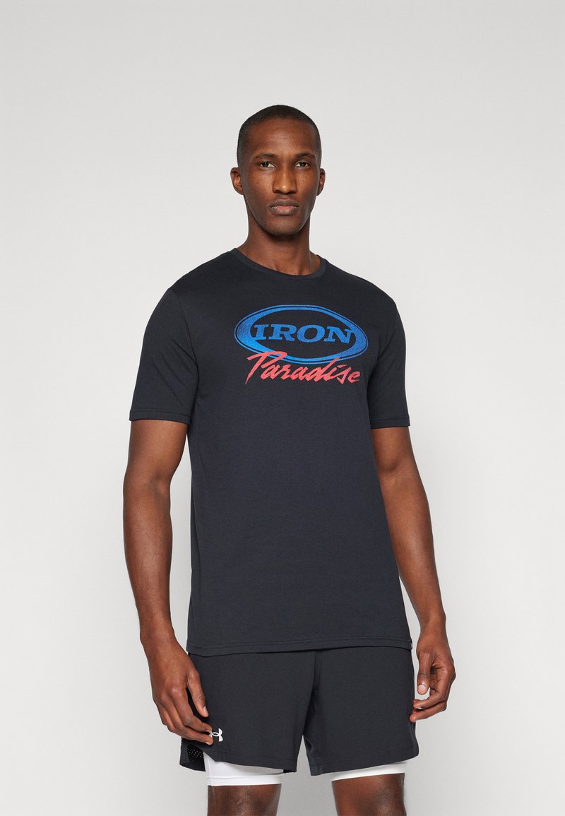 Sort bomulds T-shirt med korte ærmer, der har et blåt og rødt logo med teksten "IRON Paradise" på forsiden, parret med sorte shorts.