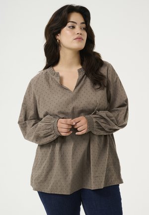 Langarmige, taupe blouse met een notch halslijn, geplooide manchetten en een subtiel textuurpatroon van kleine stippen. Ontspannen pasvorm en zachte stof.
