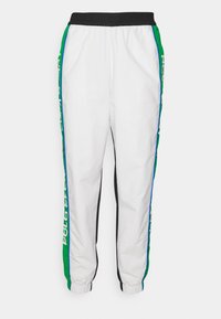 Vita träningsbyxor med svart midjeband och muddar, med gröna och blå sidostråkar med textdetalj. Släthet tyg och avspänd passform.