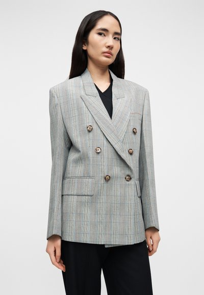 Διπλόμπουτο σακάκι σε ανοιχτό γκρι με μπλε και καφέ ρίγες. Διαθέτει μεγάλες κουμπότρυπες και δομημένη σιλουέτα.