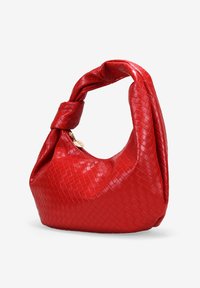 Bolso hobo de cuero tejido rojo con un asa retorcida. Presenta una textura suave y lisa y una silueta redondeada. Detalles en hardware dorado visibles.