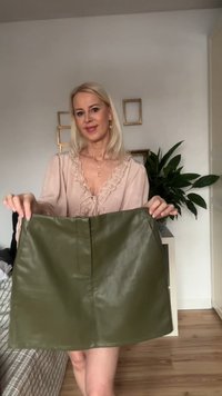 Mini kjol i olivgrönt läder med en slät yta, med en centrerad söm och en enkel, rak skärning.