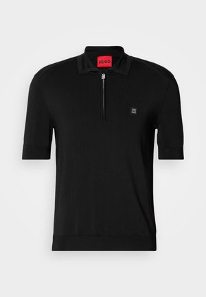 Black short-sleeve polo shirt with half-zip front, small side logo patch, and red brand label inside the collar.