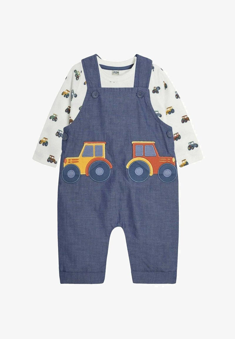 Denim-Latzhose mit zwei bunten Traktor-Applikationen auf der Vorderseite, kombiniert mit einem weißen Langarmshirt mit einem durchgehenden Traktor-Druck.