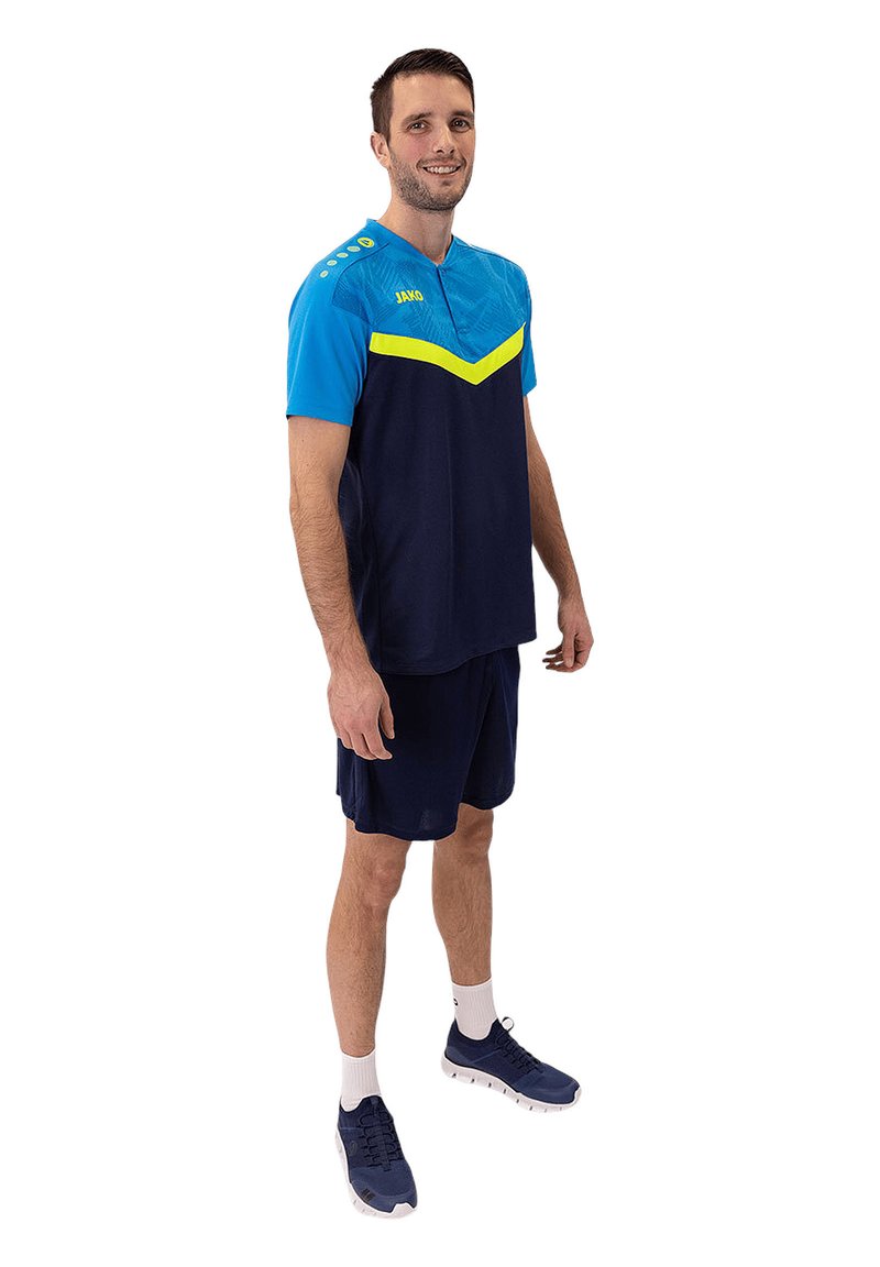 Das sportliche Outfit für Männer besteht aus einer blauen und dunkelblauen Farbgebung mit einem gelben Chevron-Design. Hergestellt aus leichtem Material, umfasst es Shorts und Sportschuhe.