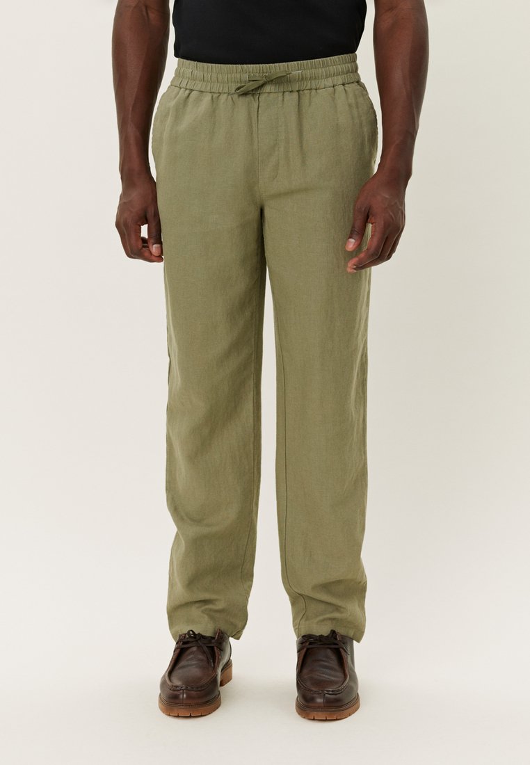 Pantaloni din in de culoare verde măsliniu, ușori, cu un elastic la talie, detalii cu șnur și o croială lejeră. Prezintă picioare drepte și o textură subtilă.